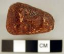 Piece of copal carved into a head (human), with a hole through the back side.