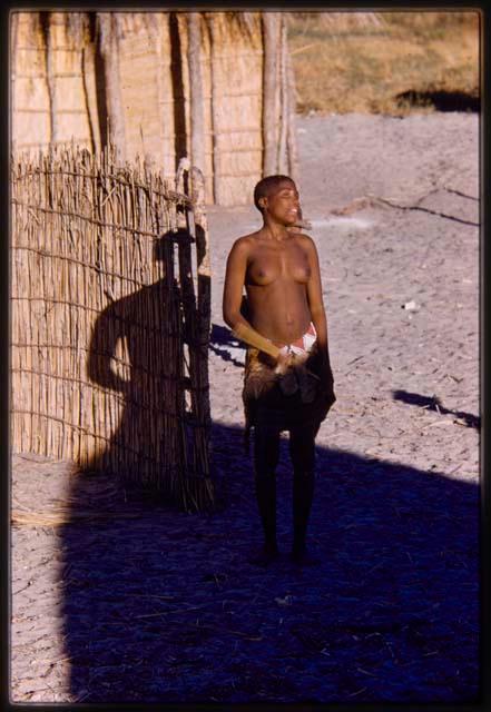 Person standing near a village hut