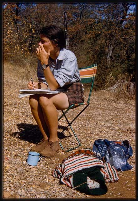 Deborah Marshall sitting in a chair and sketching by river