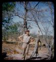 Charles O. Handley Jr. standing next to a dead leopard hung from tree