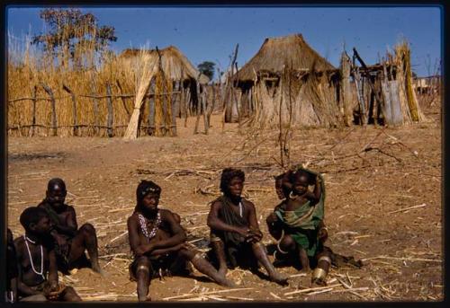 Village huts with a group of people sitting in the foreground