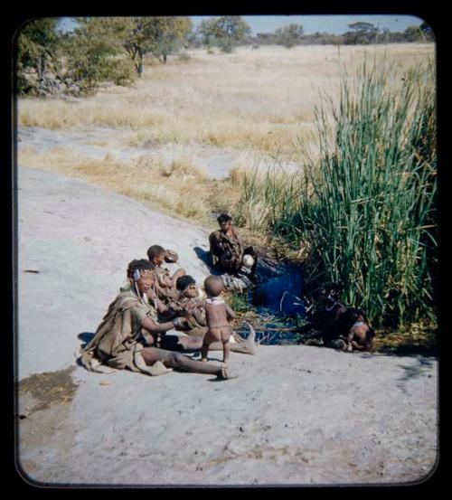 Group of women (including !U and Norna) sitting at waterhole