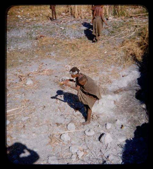 Woman holding a baby on her back at waterhole