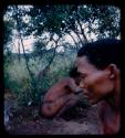 ≠Toma digging, with his face obstructed by a man in the foreground