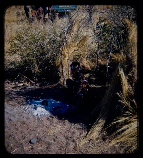 Woman sitting by ashes of fire