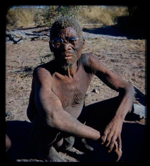 Elderly man wearing glasses, seated