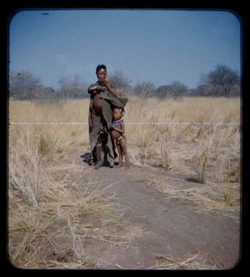 Woman in kaross, standing with a child [streaked]