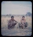 Man and woman squatting in grass