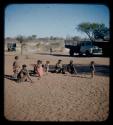 Group of people with children in camp, showing one child wearing a dress