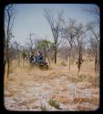 Expedition members in a truck, with a boy walking ahead of them