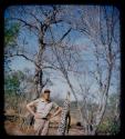 Charles Handley standing next to a dead leopard hung from tree