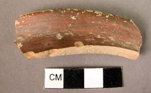 Monochrome red glazed rim fragment