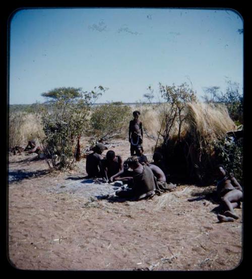 Groups: Group of men working by a skerm, with a girl standing