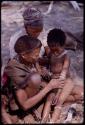 Woman removing bracelets from a girl's arm