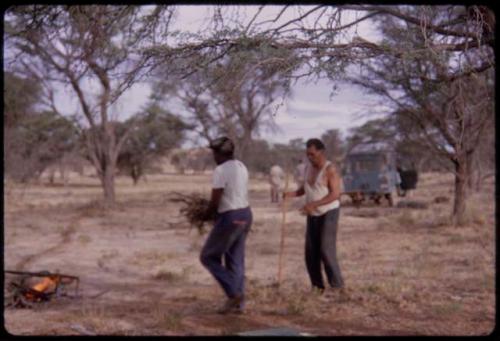 Philip Hameva starting the cooking fire, Wilhelm Camm raking the grass and leaves