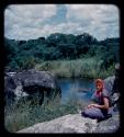 Elizabeth Marshall Thomas sitting on rocks above the Kavango River