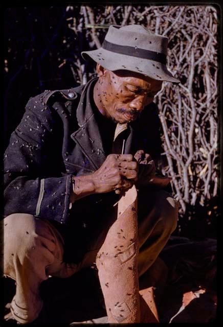 Boys sewing, covered in flies