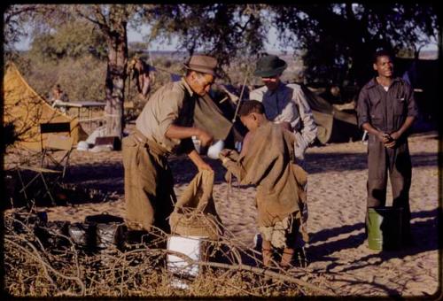 William Donnellan, Lorna Marshall, and Kernel Ledimo handing out rations