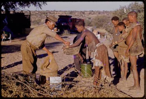 William Donnellan, Lorna Marshall, and Kernel Ledimo handing out rations