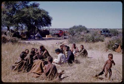 Lorna Marshall, Kernel Ledimo, and Dabe interviewing people, seen from a distance