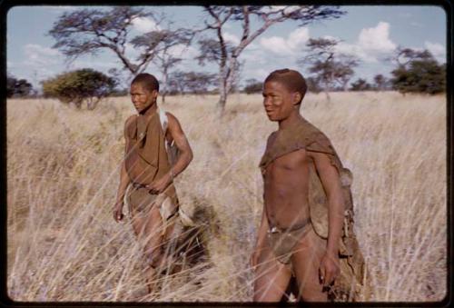 Two men walking in the grass