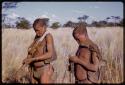 Two men standing in grass after receiving tobacco