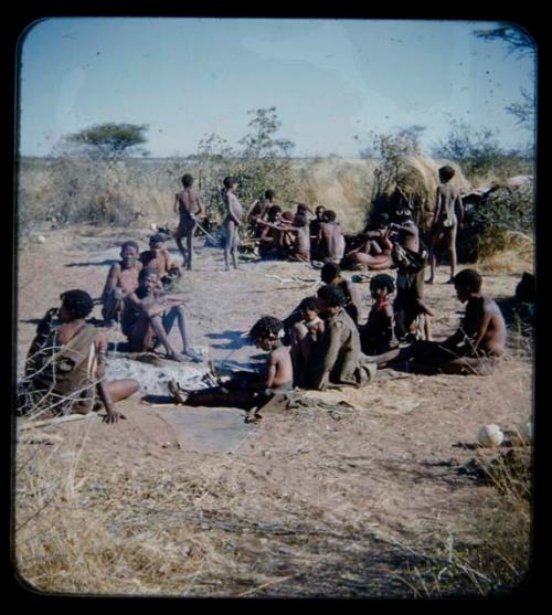 Music: Group of people gathered, with a girl playing a //guashi at the center in the foreground