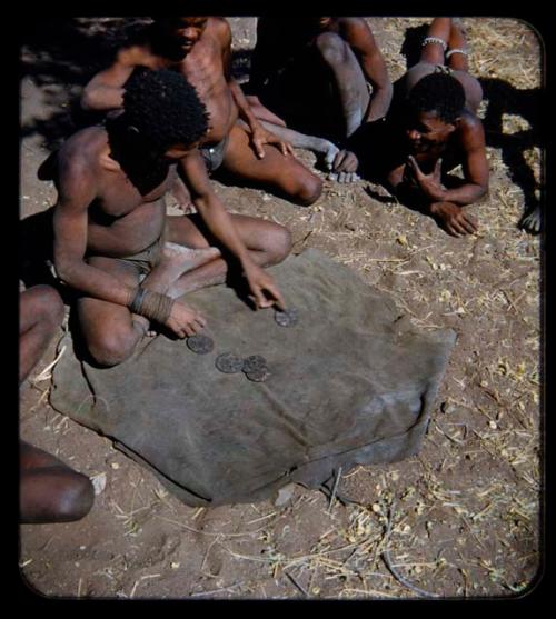 Oracle Disk: Man pointing to an oracle disk, with other people watching him