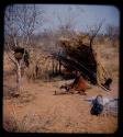 Portraits: Elderly woman sitting in front of grass shelter