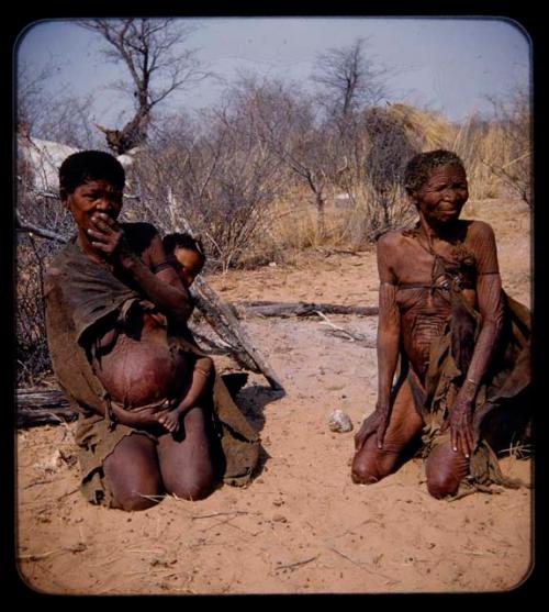 Portraits: Woman with a child on her back and an elderly woman kneeling on the ground