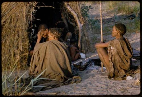 Group of people sitting, gathered near the entrance of a skerm