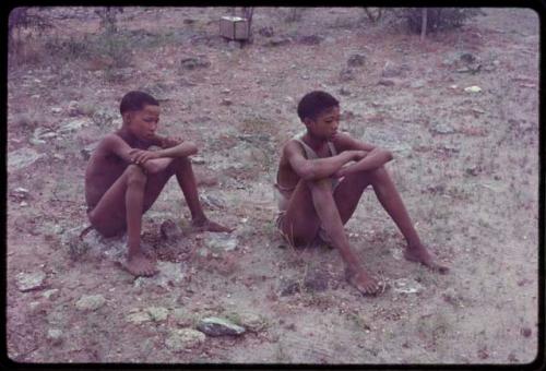 Two boys sitting on the ground