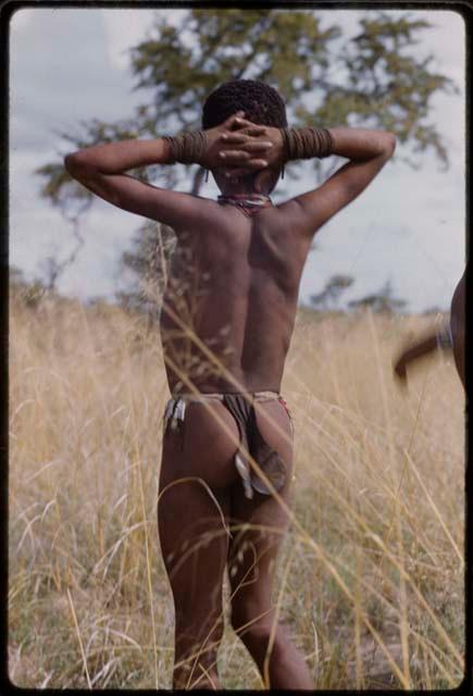 Boy locking his hands behind his head, seen from behind