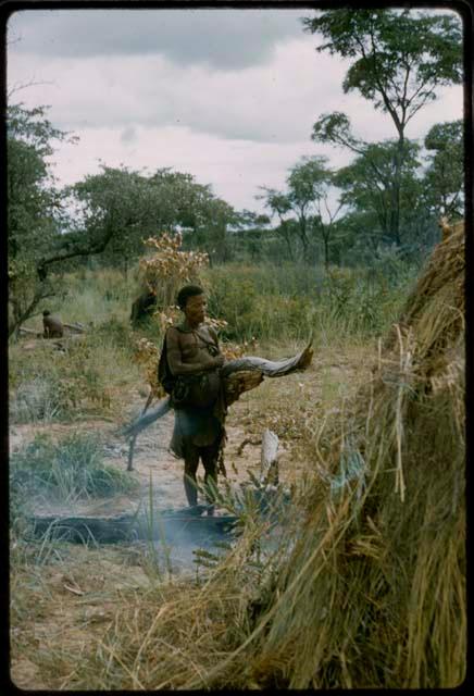 Man carrying loads of wood to a skerm