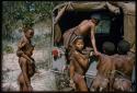 N!ai climbing into the back of Jeep, with other children standing nearby