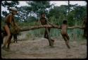 Group of boys playing with a swinging log