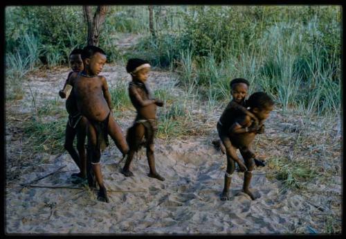 Five children at play, including one boy carrying another on his back