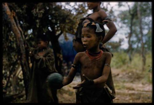 Child holding a veldkos, !’hu kuitzi (veldkos game)