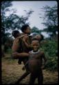 Four children playing at !’hu kuitzi (veldkos game); two children are hanging onto another