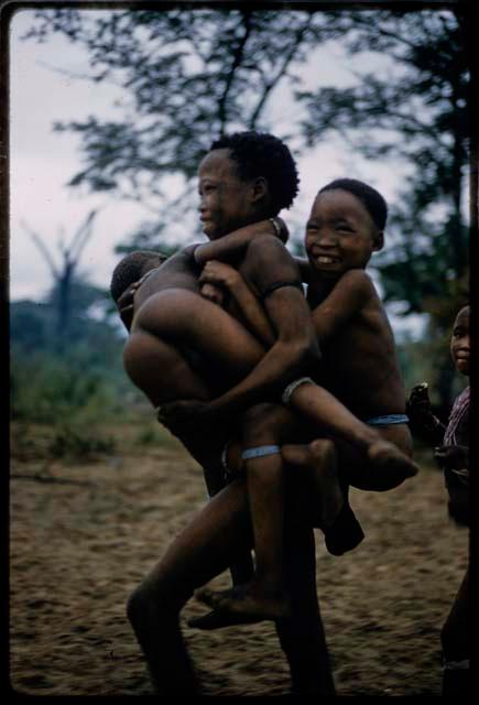 Two children hanging onto another at !’hu kuitzi (veldkos game)