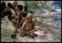 Debe (son of Kxao) playing with a can, with a group of people in the background