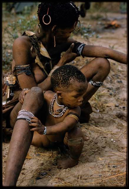 Hxua//a and her baby (!Nanni) sitting on the ground