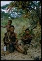 Baou (Bo's wife) with a mortar and pestle, sitting with children