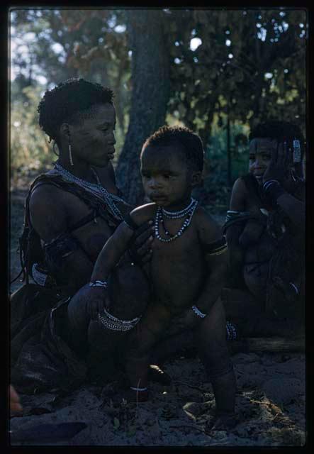 Hxua//a and a woman sitting with children