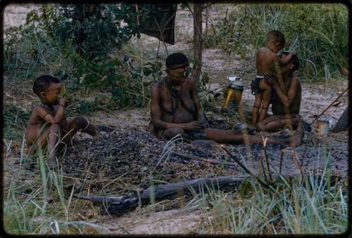 !U and her children sitting by a pile of mangetti nut shells