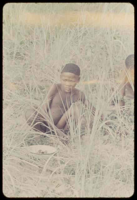 Two boys sitting in the grass