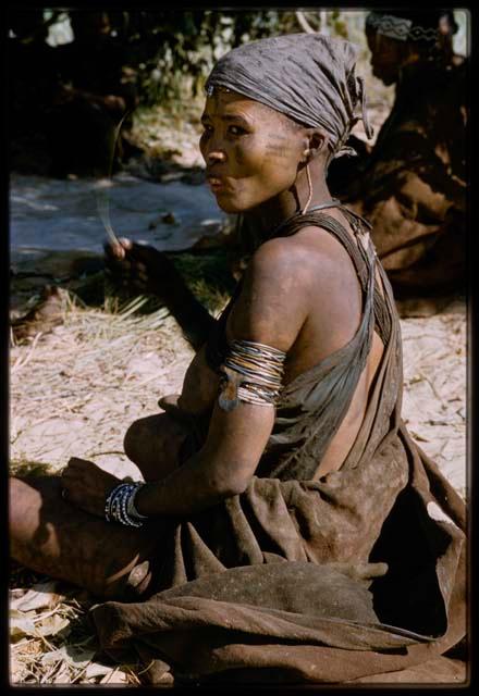 Woman wearing a kerchief, sitting, in profile