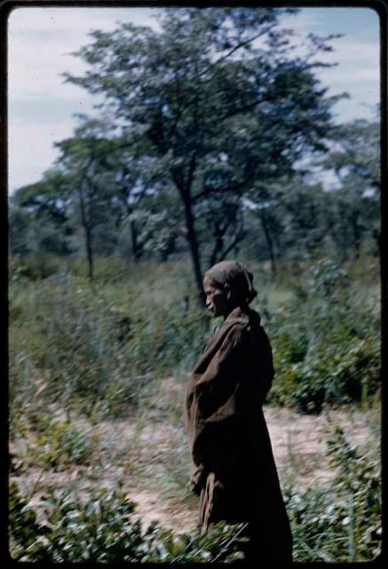 Woman standing, wrapped in her kaross