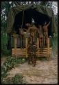 Six boys gathered near the back of a truck and Robert Story monitoring a sound recording inside