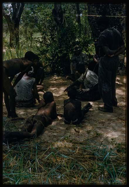 People sitting with expedition members, playing /Ui (the counting game)